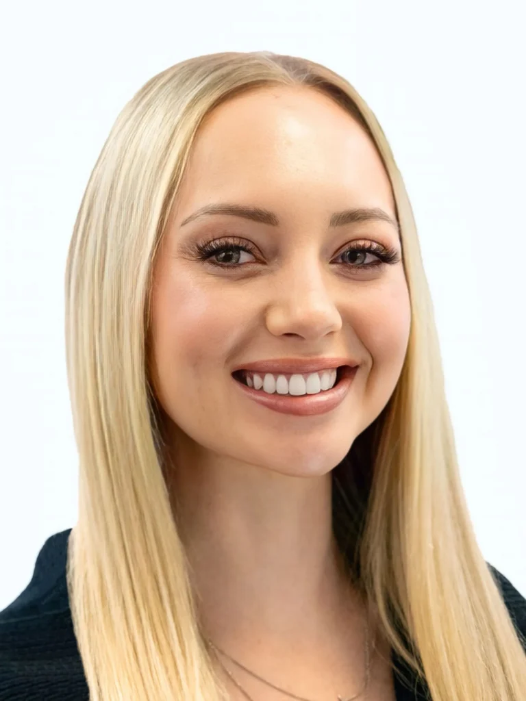 Professional headshot of a smiling woman with long blonde hair and neutral makeup.